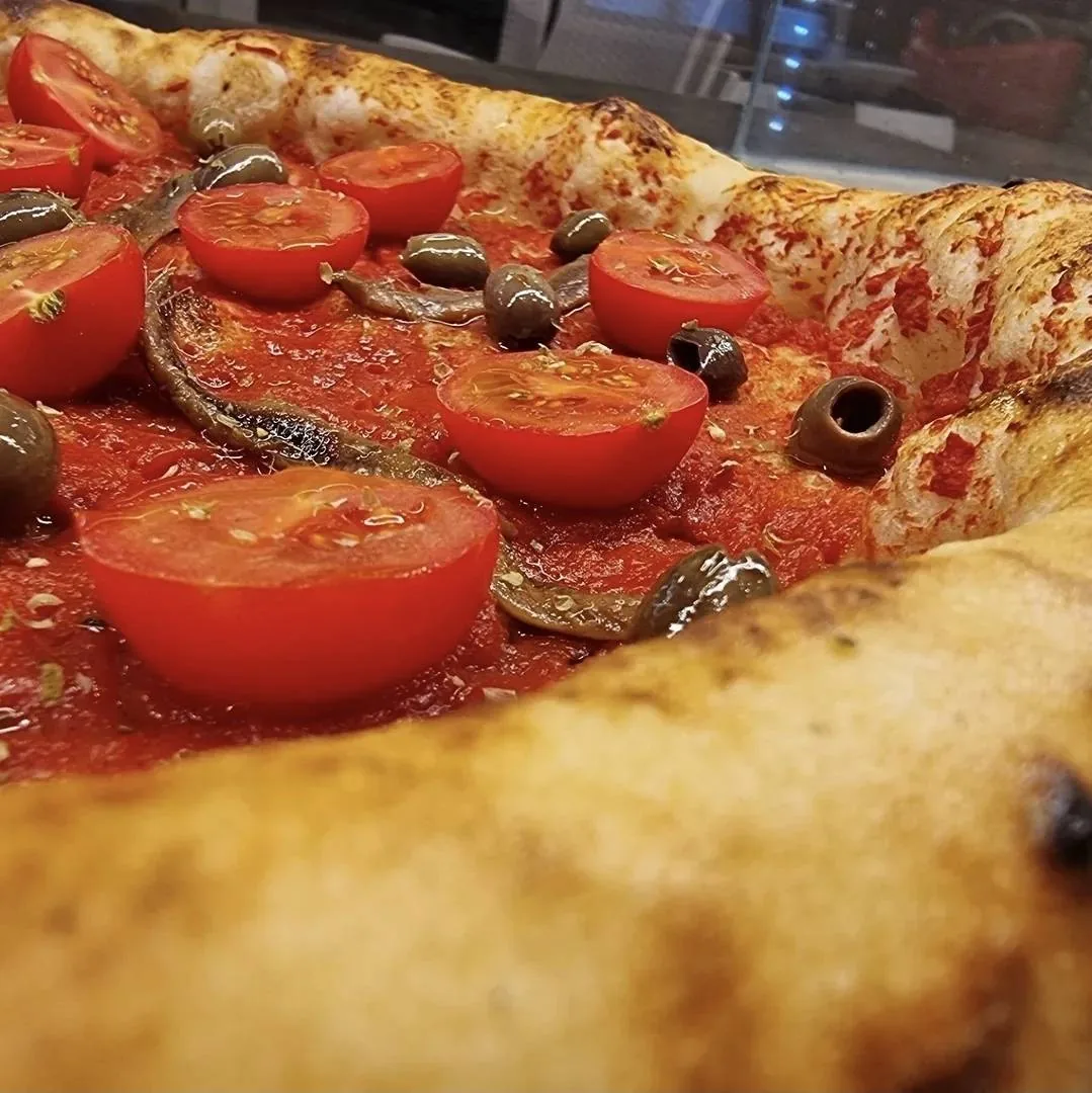 Dettaglio di pizza con pomodori e olive
